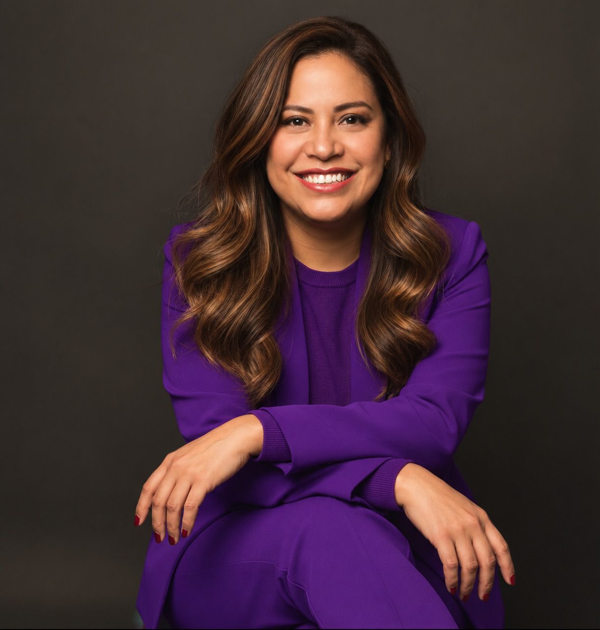 Retrato de Ana Casalegno con traje morado sobre fondo oscuro.