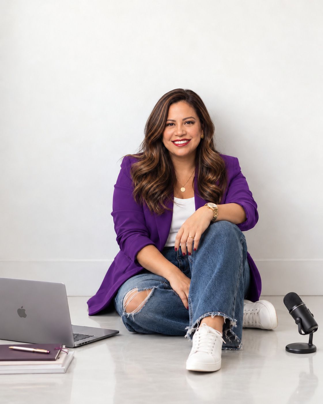 Ana Casalegno, fundadora de Faith Creative Studio, sentada en el suelo del estudio junto a un portátil, cuadernos y un micrófono.